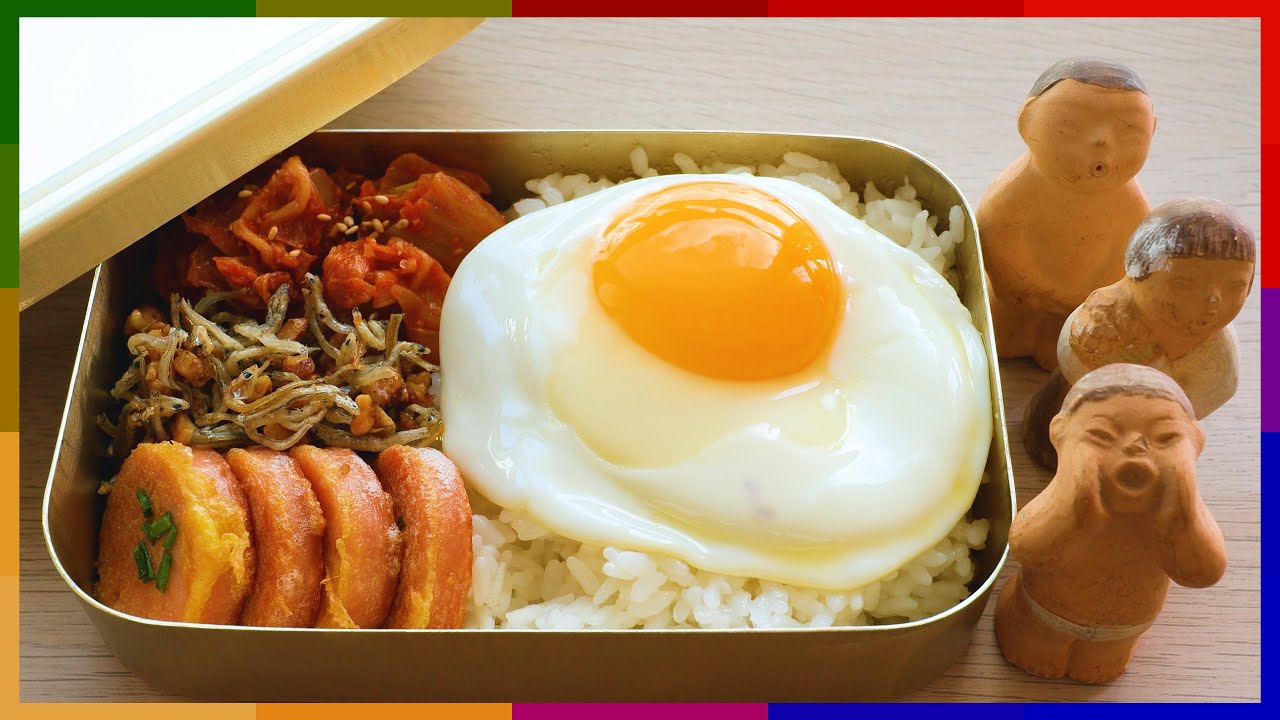 A 4K detailed view of a retro 1970s Korean dosirak with rice fried egg kimchi pink fish sausage and a small portion of side dishes