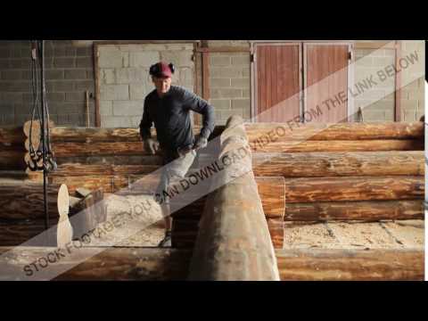 A man inspects beam house on the accuracy of the installation. Wooden house half built