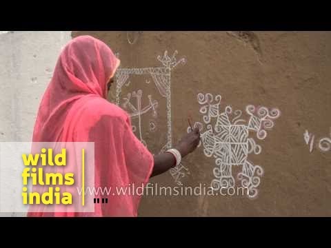 mandana wall art being painted by rajasthani woman