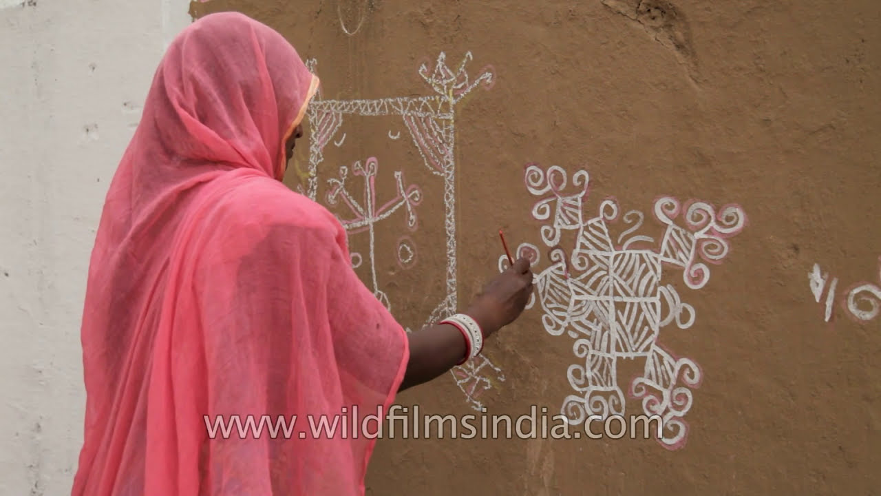 mandana wall art being painted by rajasthani woman