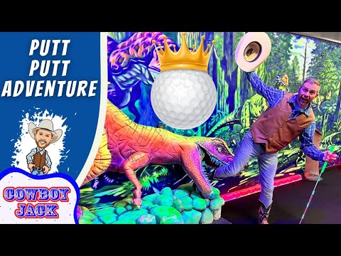 Man in a cowboy vest and hat poses with a neon dinosaur in a colorful putt-putt adventure scene; a crowned golf ball hovers above.