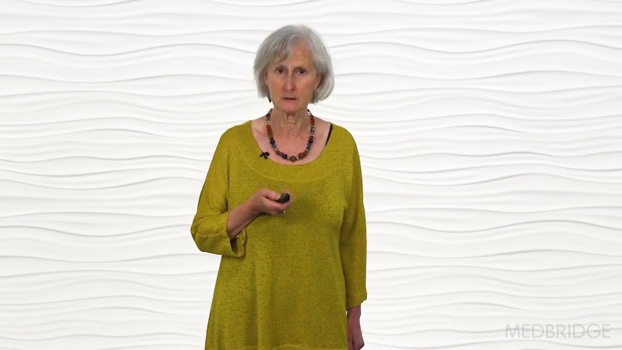 An older woman in a yellow top holds a remote against a textured white background, highlighting Medbridge's blend of healthcare education and technology.