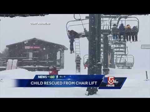 Young skier dangles from chair lift