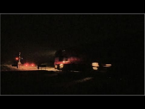 Late Night Freight Train at an Australian Railway Level Crossing with Boom Gates