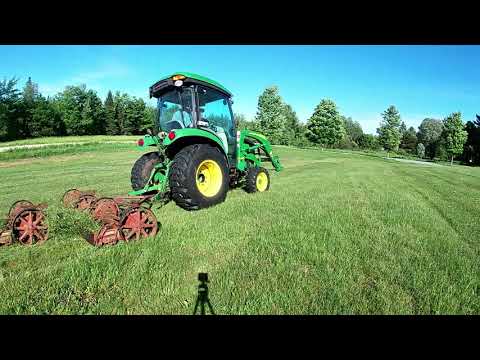 John Deere 3046r cab tractor pulling an antique Toro reel set.