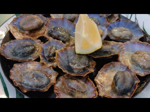 Eating Lapas in Funchal Madeira. Grilled Limpets in Garlic Butter with A Squeeze of Lemon