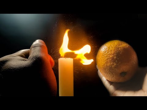 Squeezing Orange Peel near the fire in slow motion