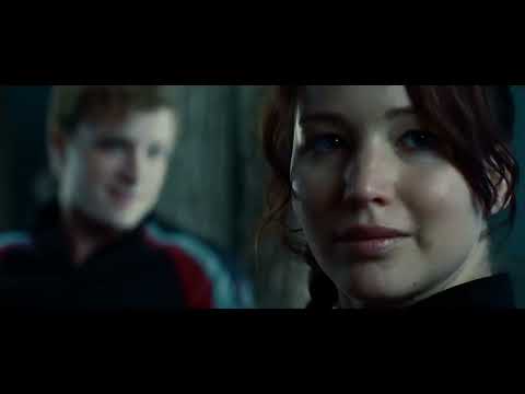 Official trailer still: Katniss volunteers at the reaping as the crowd falls silent