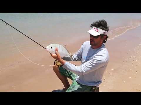 The man is teaching how to fish by the sea.