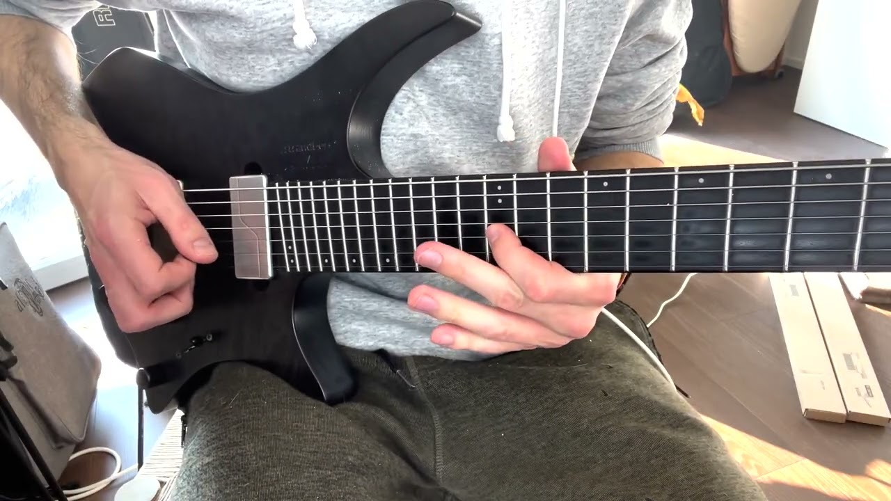 Close-up of a hand pre-bending a guitar string before picking, demonstrating the pre-bend lick technique