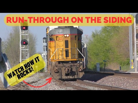 A long freight train with a DPU runs through on the siding as the local works the Main line