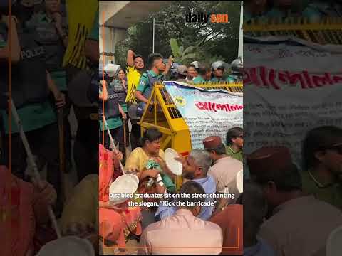 Disabled graduates sit on the street chanting the slogan, "Kick the barricade."