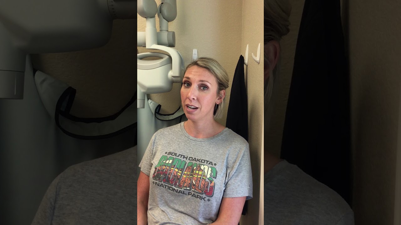 Woman in gray tee shirt sitting in dental office