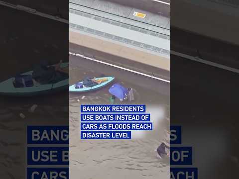 Bangkok residents use boats instead of cars as floods reach disaster level