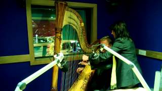 Lucinda Belle teaching Nigel Williams how to play the harp