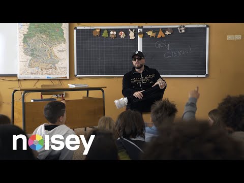 Guè answers questions from a group of children about money, cars, and Cristiano Ronaldo.