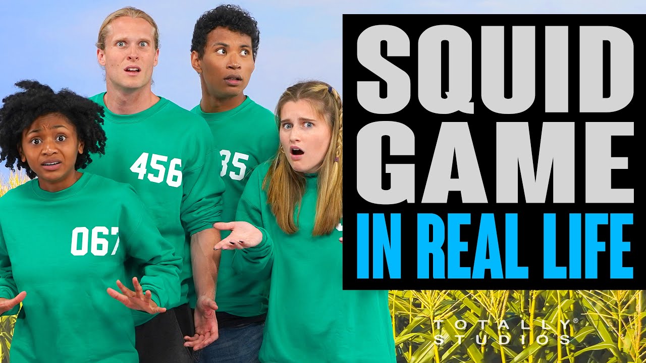 People in green Squid Game tracksuits recreating the Red Light Green Light game in real life with the giant doll prop standing at the end of an open courtyard