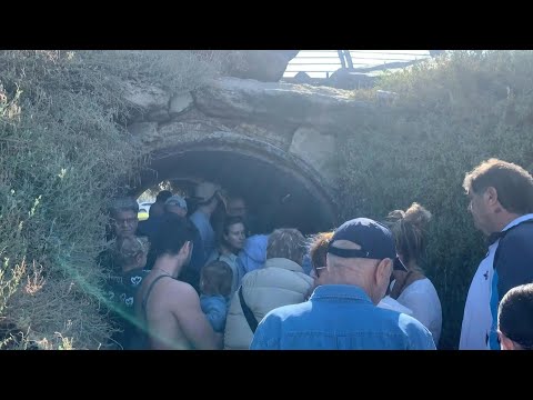 People on beach promenade take shelter as sirens blare in Tel Aviv | AFP