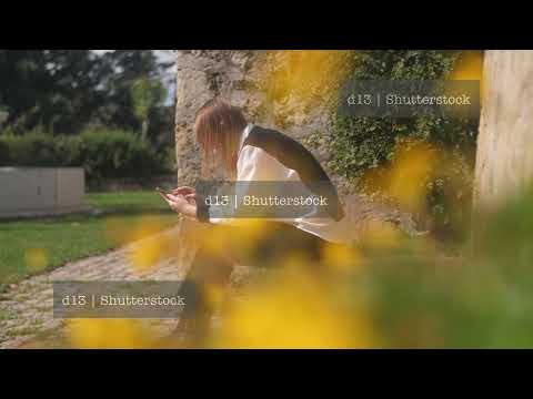 Allergic woman sneezing while relaxing in the park near blooming flowers