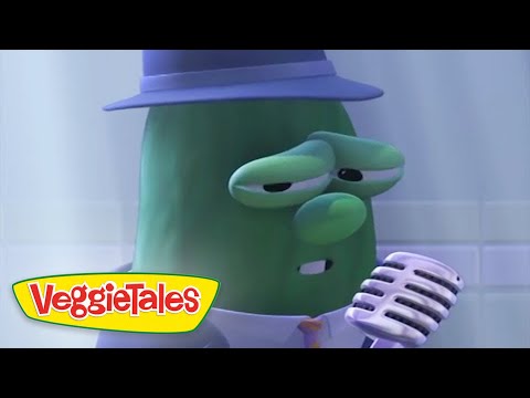 Green veggie character wearing a purple hat sings into a retro microphone on a stage, VeggieTales logo in the corner.