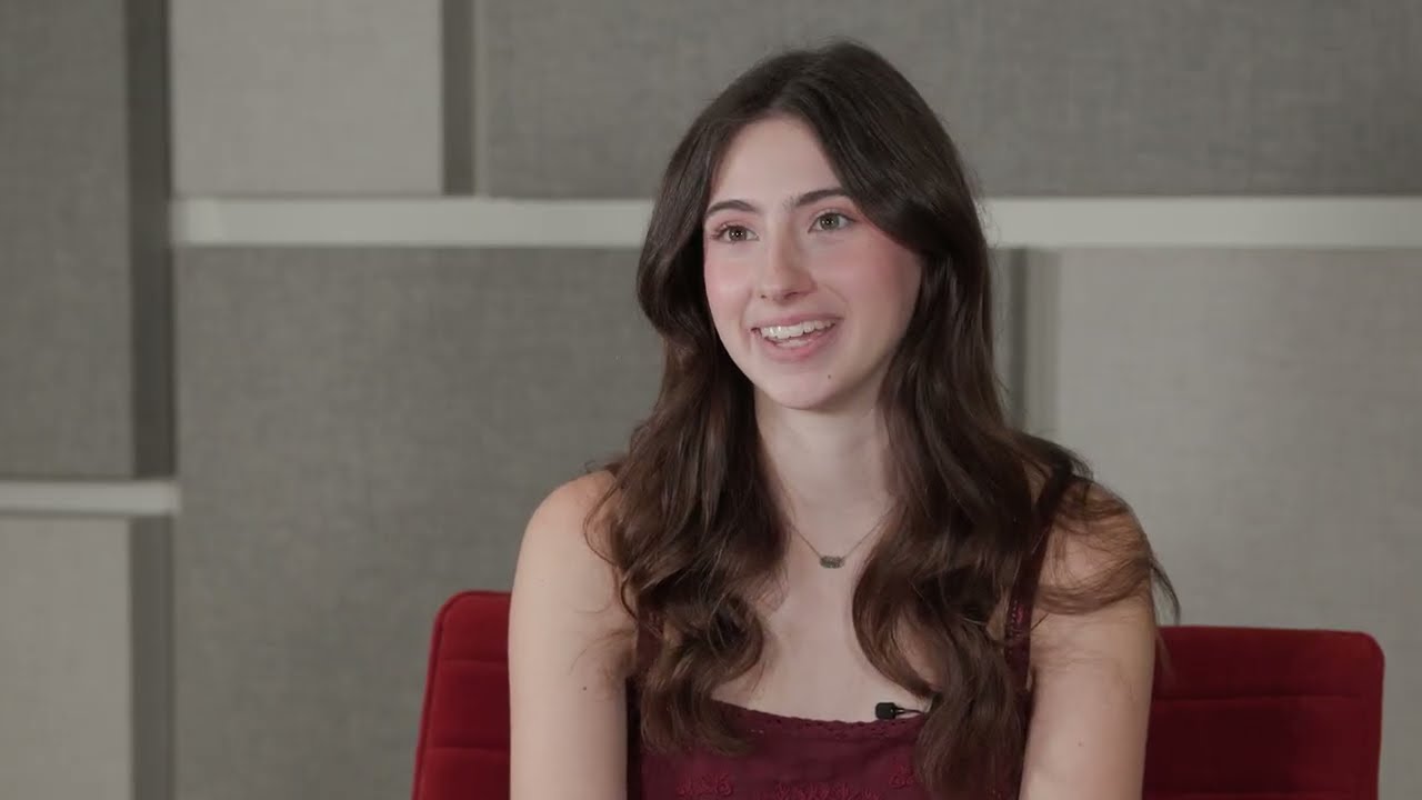 Natalie Hall sits in a chair giving an interview
