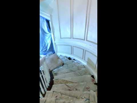 Curved staircase and Foyer entry with wainscoting.