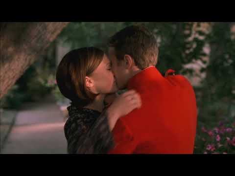 Library stacks and rain-drenched streets as the pop cues soften into strings