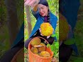 Opening A Freshly Harvested Spiky Yellow Fruit From The Orange Woven Basket
