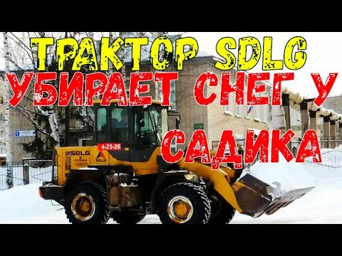 Трактор SDLG убирает снег у садика
