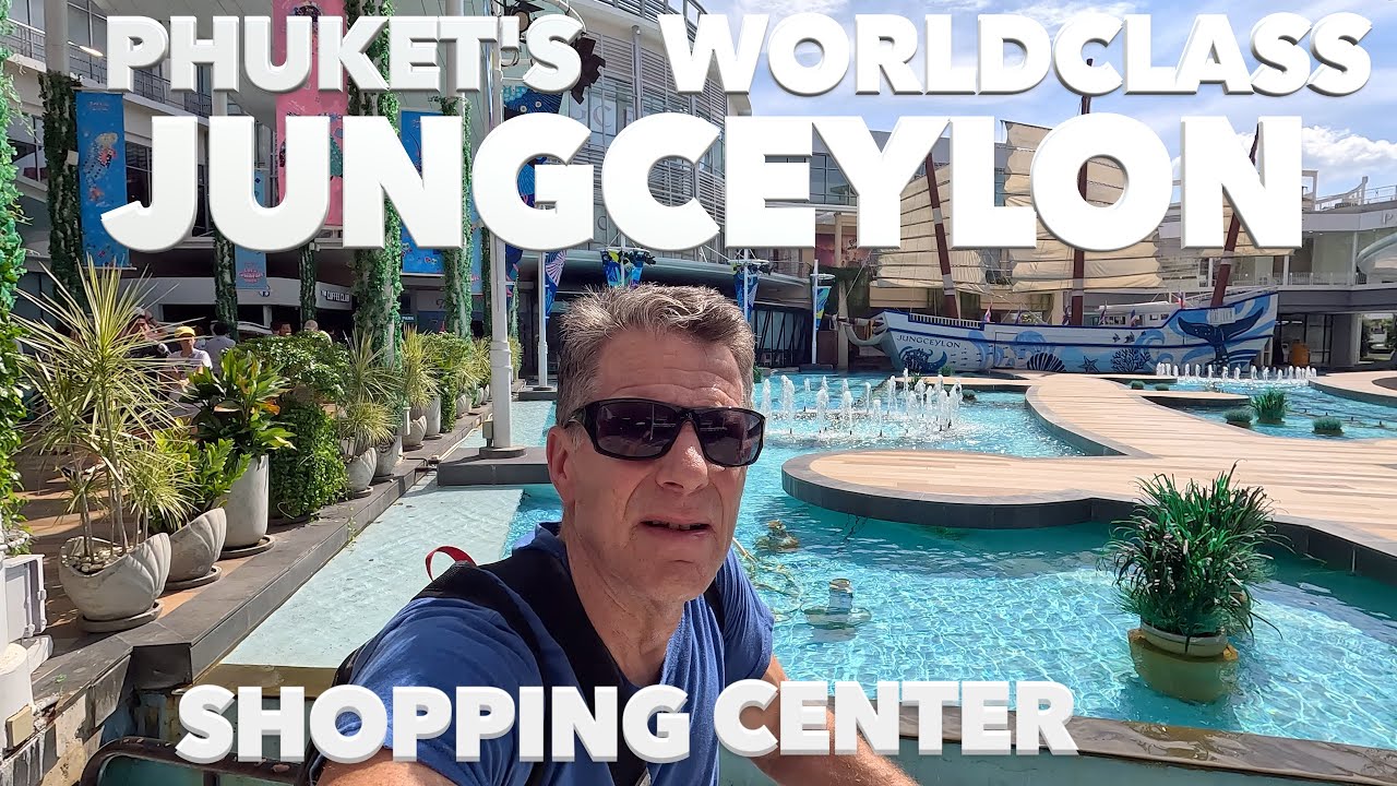 Experience the vibrant interiors of the mall, glowing night lights, central plaza's captivating fountain/boat structure amidst the lively crowd atmosphere in Patong.