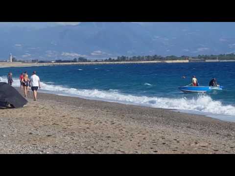 Barca in difficoltà l'aiuto di alcuni marinai sulla spiaggia