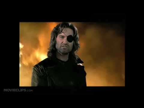 Trailer still: Snake under helicopter lights; low synth ostinato building