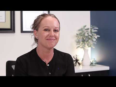 Woman in black blouse smiling in dental office