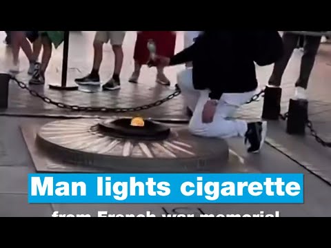 Man lights cigarette from French war memorial