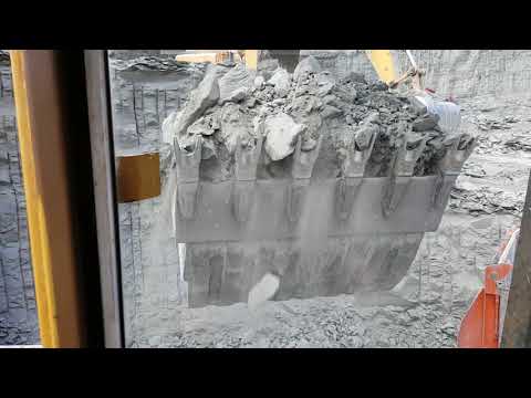 Caterpillar 245B loading trucks with 4 passes