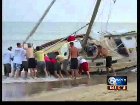 People help push sailboat back out to sea