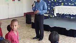 Edmund Hinkson addresses the students of Gordon Greenidge Primary School