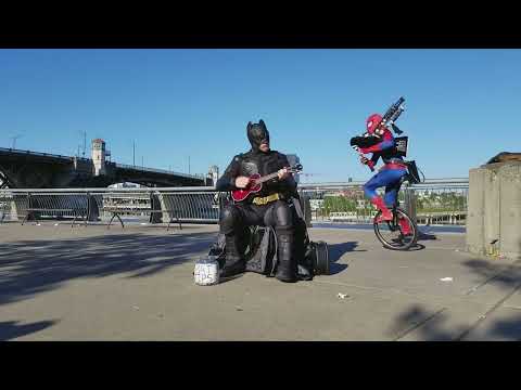 Ukulele Batman Returns to Battle Unicycle Bagpipe Spider Man in a Theme Song Throw Down!