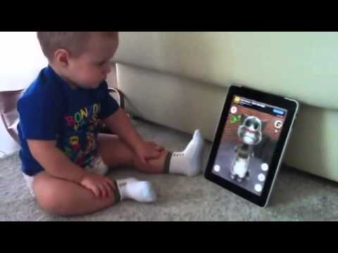 Funny baby talks with cat on iPad