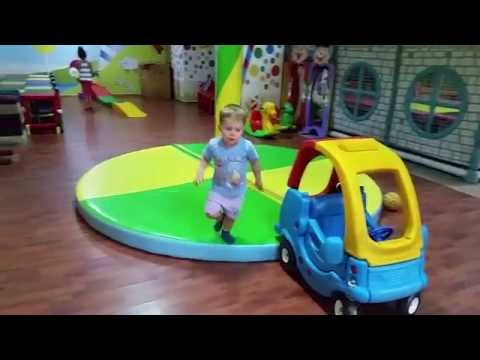 Indoor playground. Funny children run, jump and play with toys :horses, trains, balls, cars,