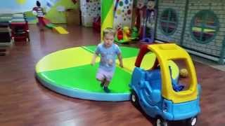 Indoor playground. Funny children run, jump and play with toys :horses, trains, balls, cars,
