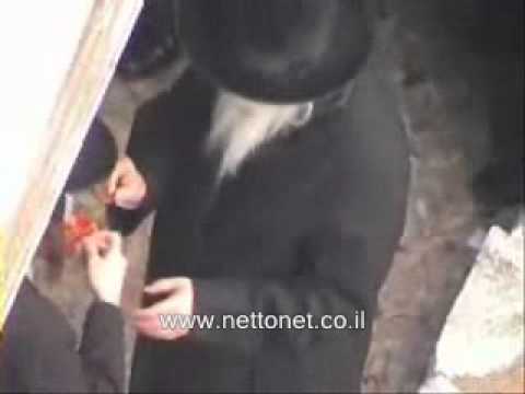 Gerrer Rebbe lighting candle at grave of previous Rebbe