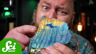 Close-up of labradorite showing the electric blue flash of labradorescence against a gray stone background