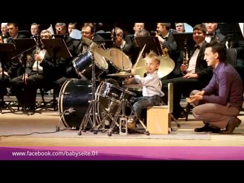 Dreijähriger dirigiert mit Schlagzeug ein Orchester
