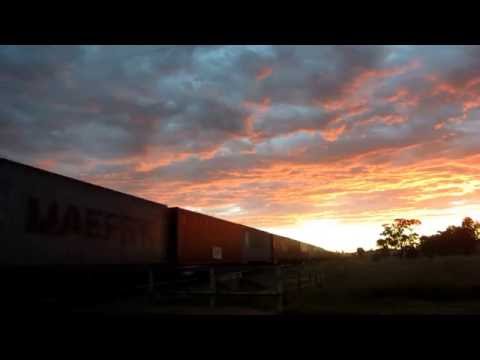 Under a colourful sunset sky, locos 1104+1107+1101+CM3303 speed through Illabo, NSW with train #3112