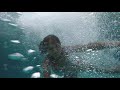 Pretty Young Woman Diving Underwater With Go Pro Camera In Swimming Pool During Sunset And Swims