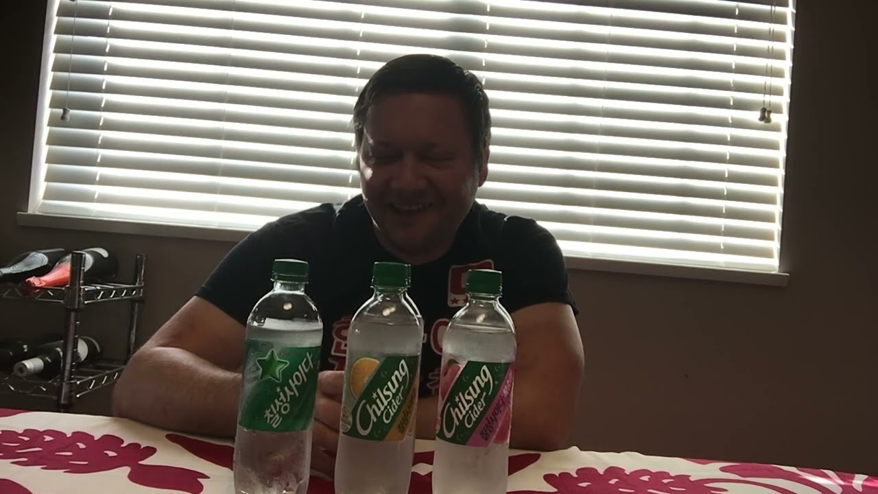 A clear glass bottle of Korean Lotte Chilsung Cider lemon-lime soda displayed with the iconic green and silver Korean label on a table