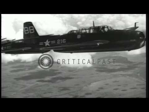 US Navy TBM Avenger aircraft flying in formation over an island in the Pacific. HD Stock Footage