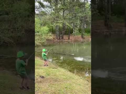 Boy Overjoyed After Catching Large Bass Out of Pond - 1128715