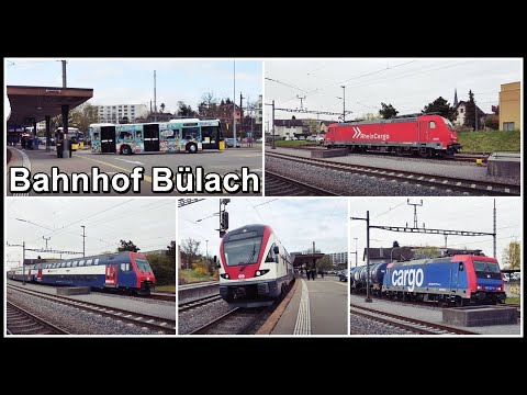 Viele Postautos und Züge beim Bahnhof Bülach, Kanton Zürich, Schweiz 2022
